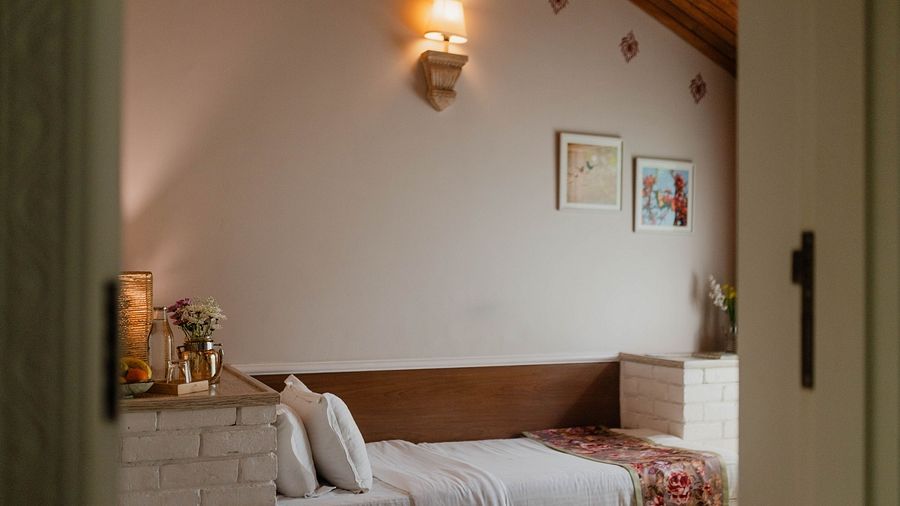 A bedroom at Karma Chalets with a single bed, wall-mounted light, and framed art.
