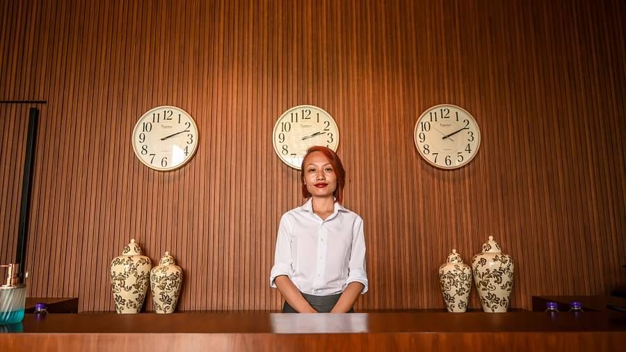 A receptionist standing at the reception of Singalila Club