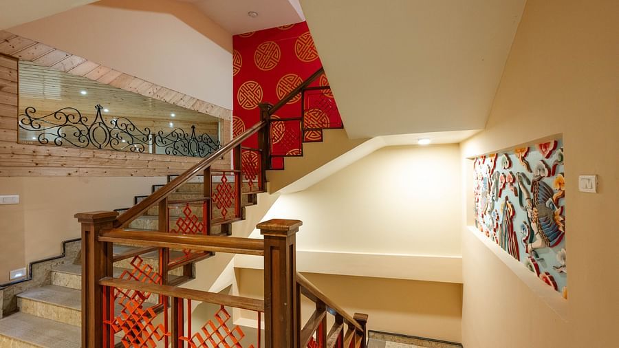 A designed staircase featuring intricate wall art at Avianna Hungry Jack, Gangtok.
