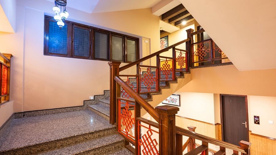 Interior view of the hotel staircase at Avianna Hungry Jack, Gangtok, featuring a stylish light hanging overhead.