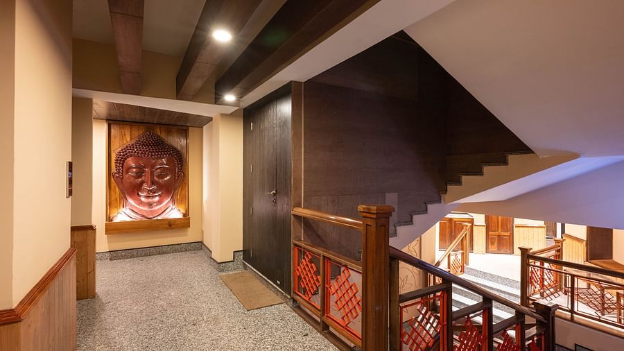 A view of a staircase with Buddha art in the corner of the corridor at Avianna Hungry Jack, Gangtok.