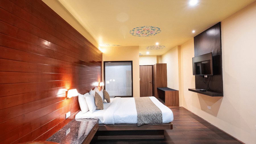 Side view of the bedroom featuring a wall-mounted television at Avianna Hungry Jack, Gangtok.