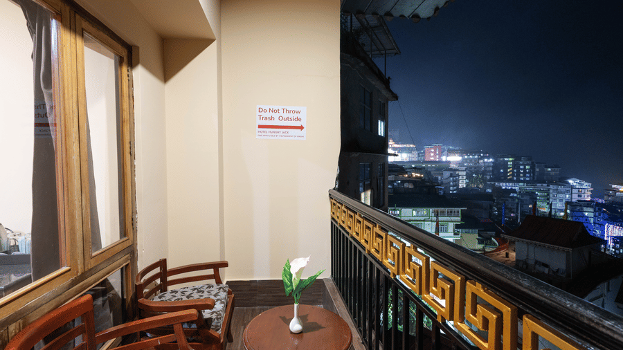 A balcony with chairs and a table at Avianna Hungry Jack, Gangtok.