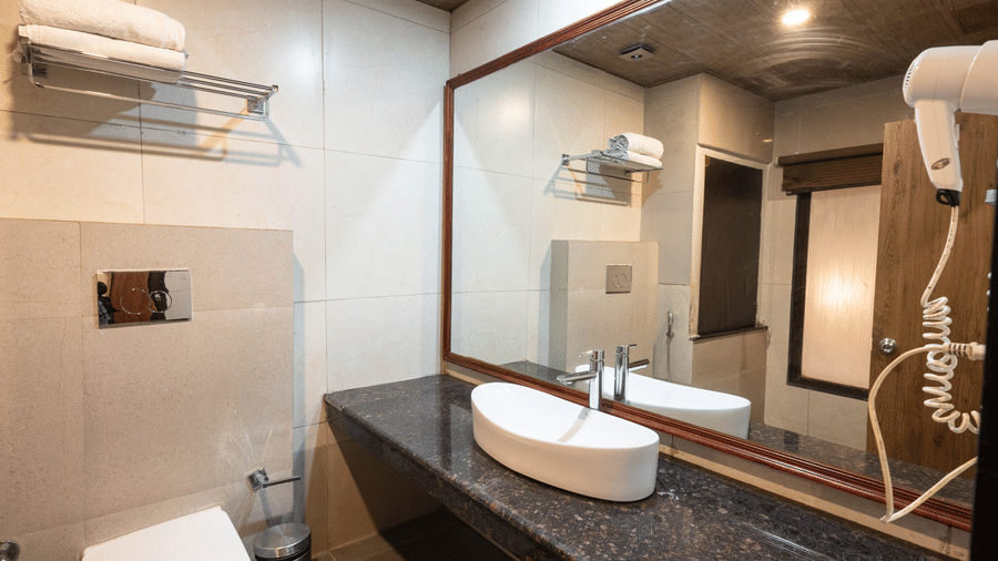 Bathroom equipped with a hair dryer and mirror at Avianna Hungry Jack, Gangtok.