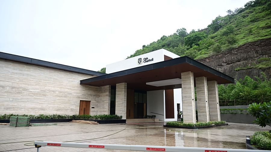 Building entrance with covered porch, barrier in foreground, hillside backdrop.