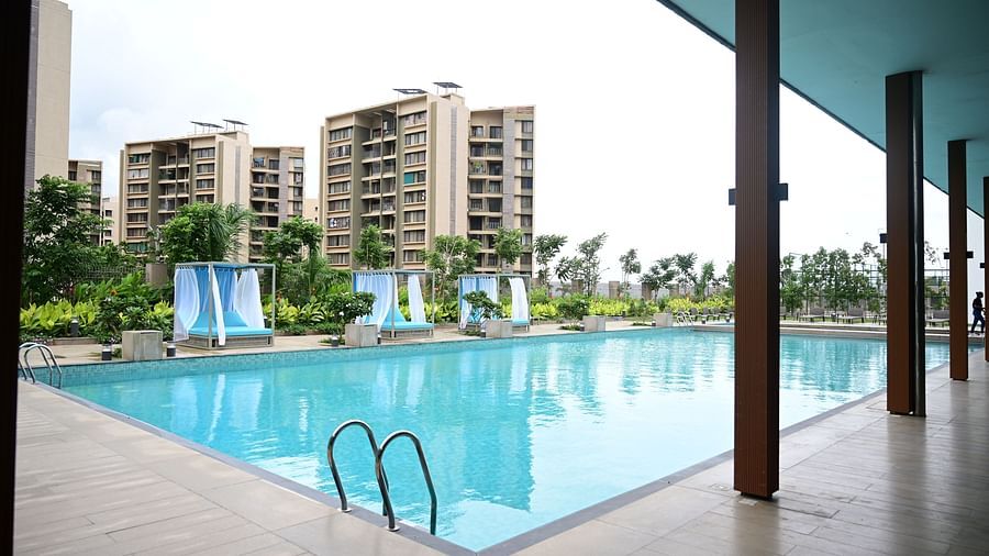 image of the swimming pool taken from under a shed with buildings in the backgroun at club charholi, pune