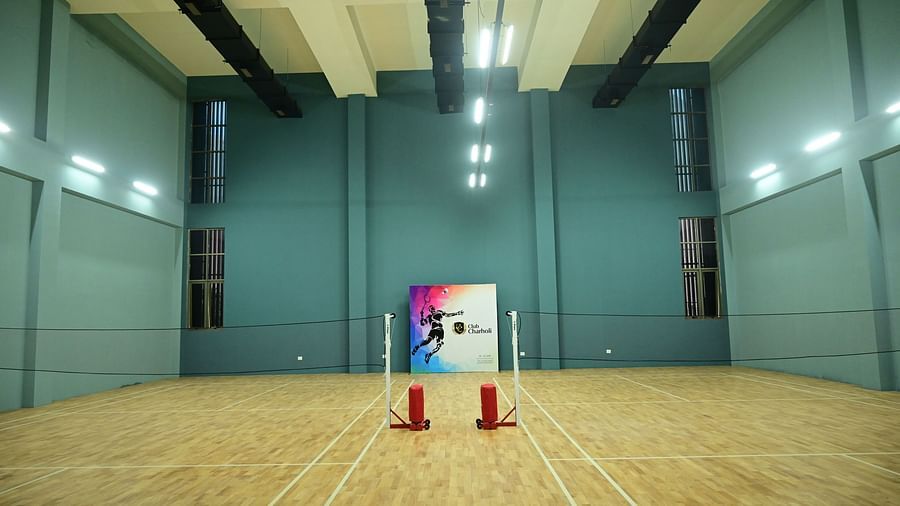 centre view image of the expansive badminton court at club charholi, pune