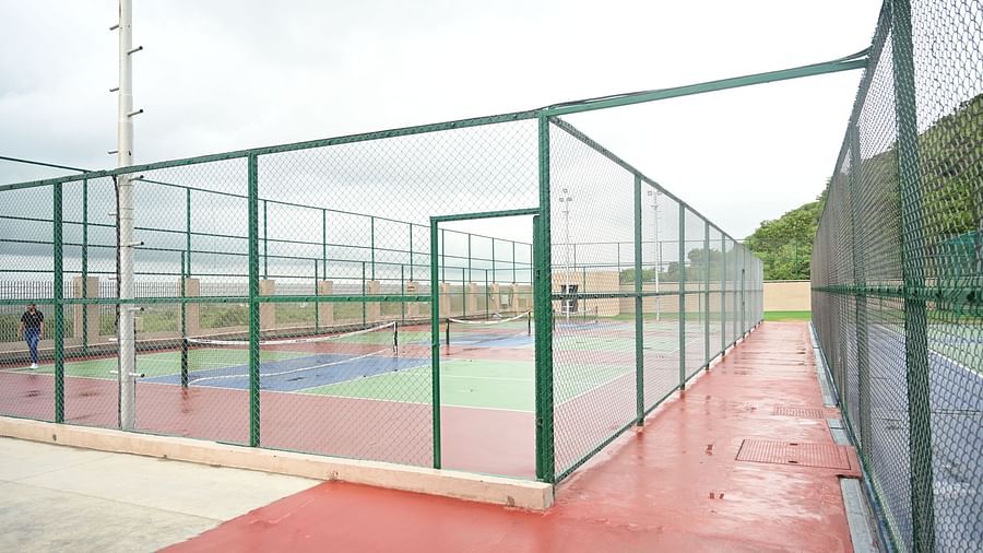 image featuring various tennis courts separated with metal grills at club charholi, pune