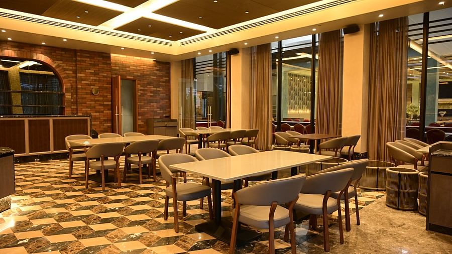 Dining area with tables and chairs, patterned floor, and textured walls.