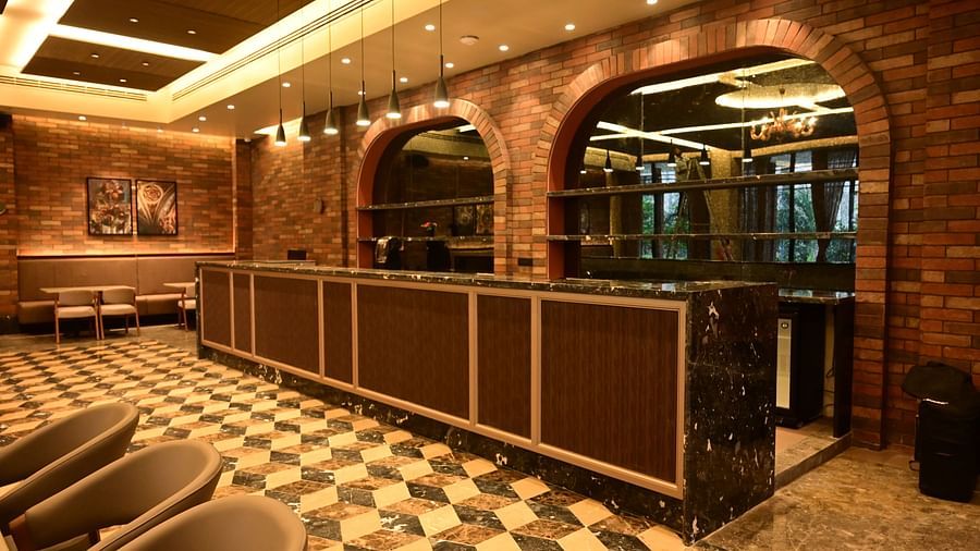 Counter with arched openings, textured walls, and patterned floor in a dining area.