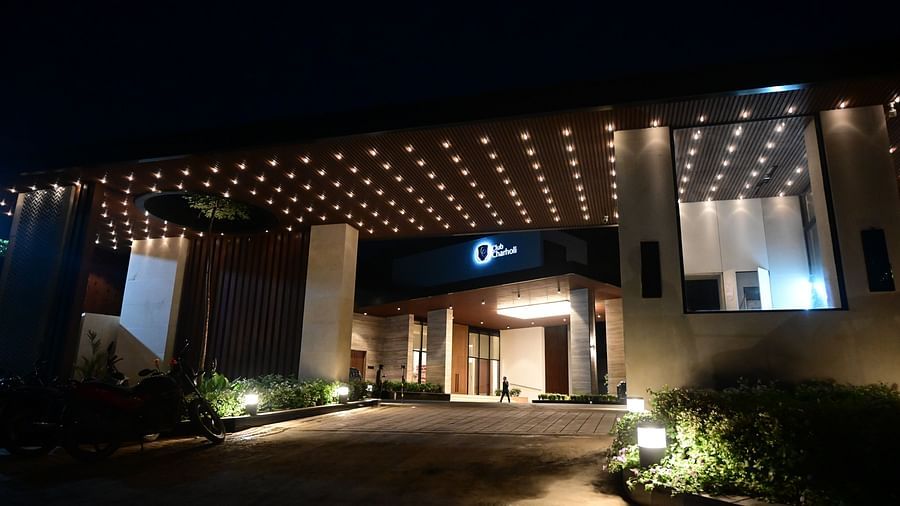 Entrance to building with illuminated canopy and a central circular emblem at night.