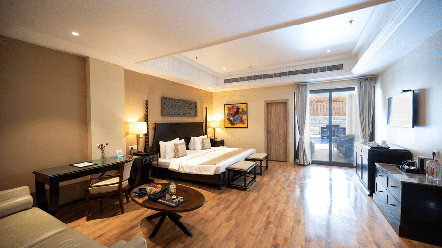Presidential suite bedroom at Essentia Luxury Resort & Spa, one of the best resorts to stay in Udaipur, with a spacious layout, modern room amenities, and a balcony