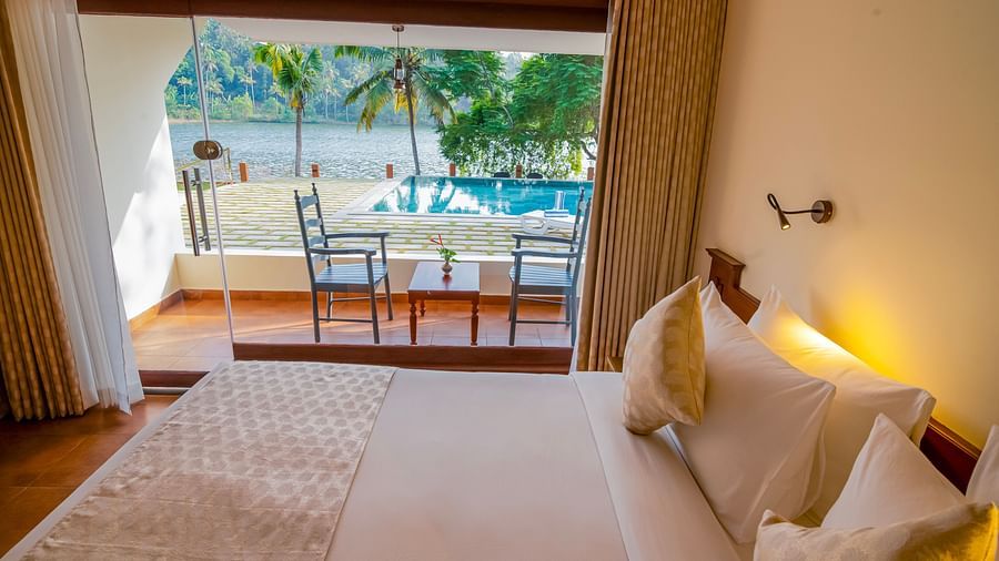 Spacious bedroom with a comfortable bed and a view of the pool and greenery.