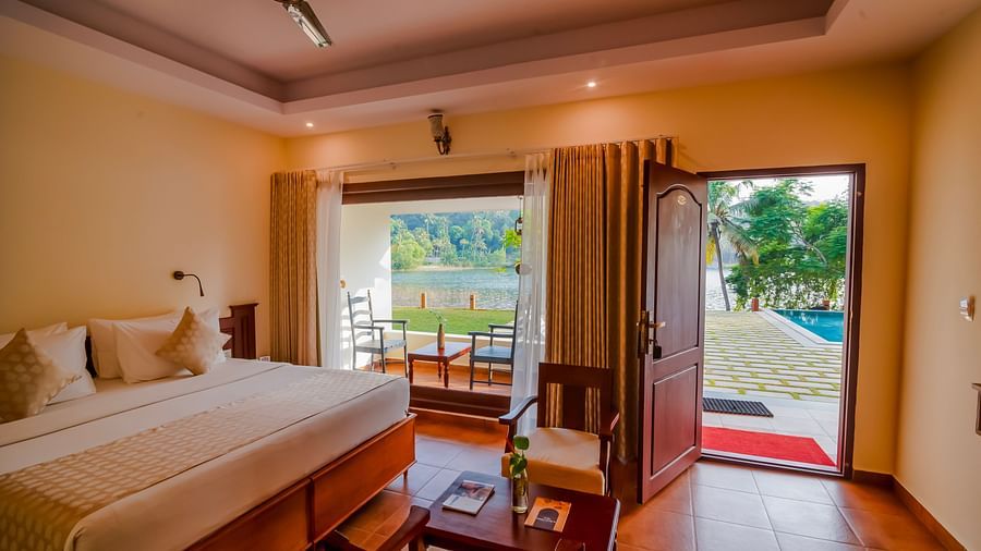 Comfortable bed with a view of the resort's lush surroundings and the water.