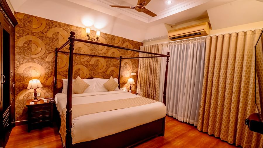Luxury bedroom with a four-poster bed and ornate decor at a resort.