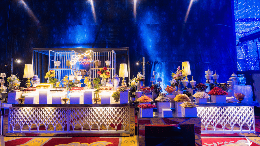 An elaborate bar or drinks service counter brightly lit with dramatic blue spotlights, featuring many bottles and glasses at Hotel Hukam's Lalit Mahal.