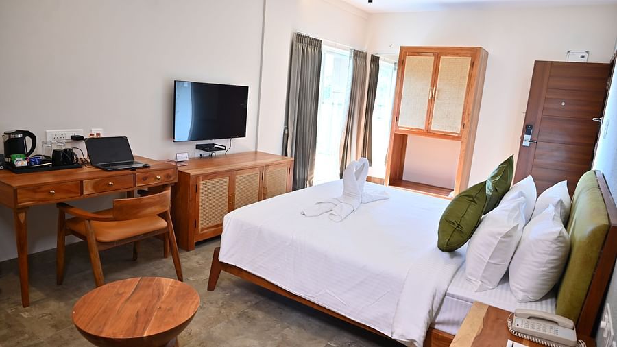 Spacious Club Suite with a comfy bed, a wooden desk, a TV, a wardrobe, and large windows letting in natural light at TGI Livancia Hillside