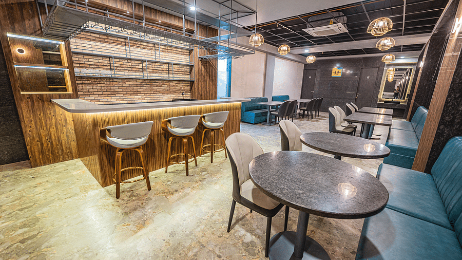 A cosy café corner with round tables and upholstered chairs, featuring warm lighting at Lotus Leaf Boutique Hotel.