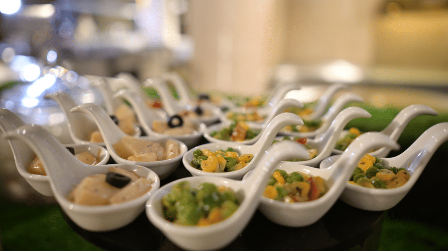 A close-up shot of elegant ceramic spoons filled with assorted canapes and appetisers at Pushkara Resort & Spa.