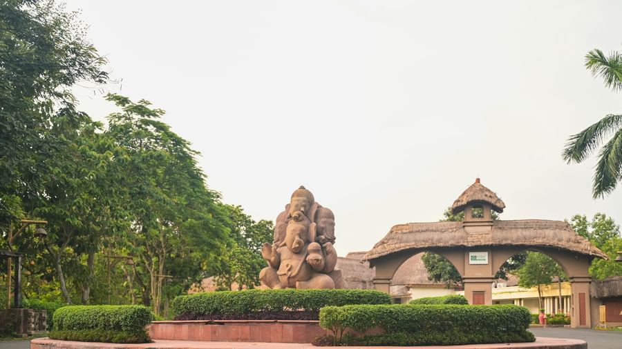 The entrance to Vedic Village Spa Resort featuring a mud sculpture and clay arch ways leading to the property.