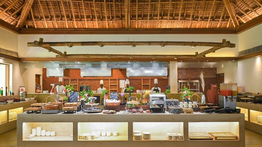 Buffet Counter in Yagna at Vedic Village Spa Resort, featuring high ceilings and chefs lined up behind the counter.