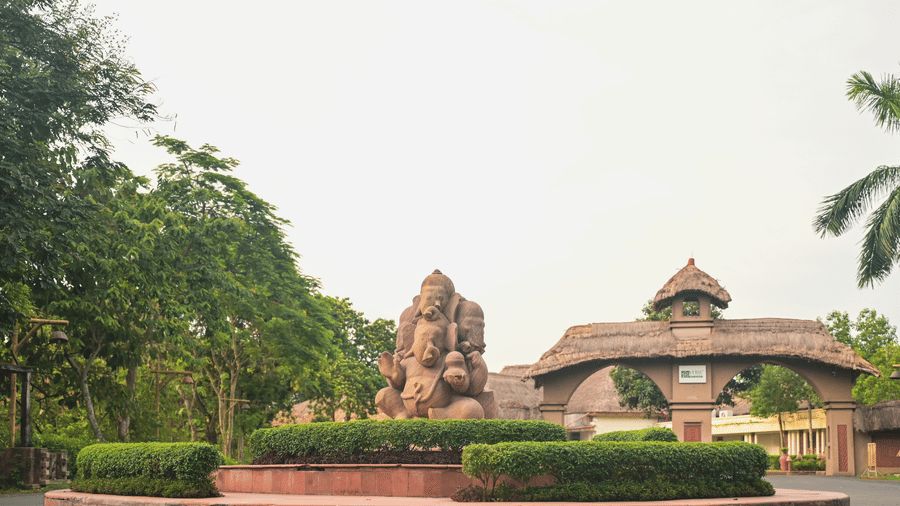 The entrance to Vedic Village Spa Resort featuring a mud sculpture and clay arch ways leading to the property.