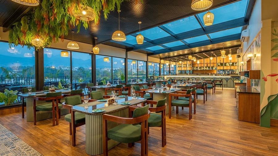  Interior of The Gaia Gourmet restaurant at Vishranti Hotel, Dehradun, featuring a well-lit dining area with wooden floors.
