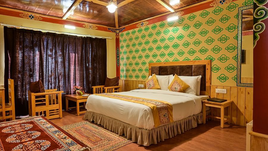 Premium Cottage at White Sands Resort, Ladakh, is decorated with patterned carpets and includes a bed and seating area.