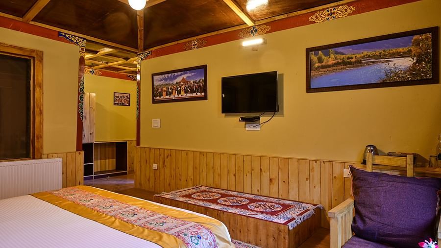 Premium Cottage in White Sands Resort, Ladakh, features a king size bed, a TV, and a comfortable seating area.