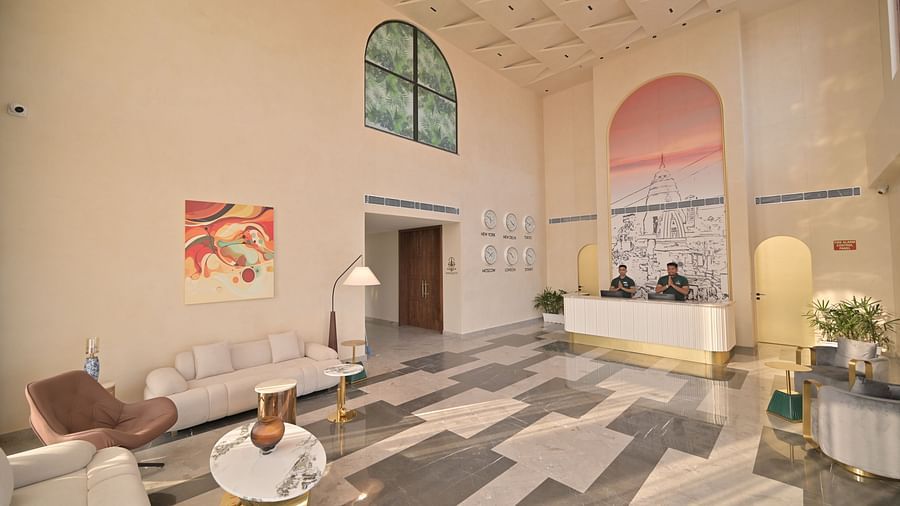 A brightly spacious lit featuring a white reception desk, modern seating, and unique floor tiling. - Clarks Safari Haridwar