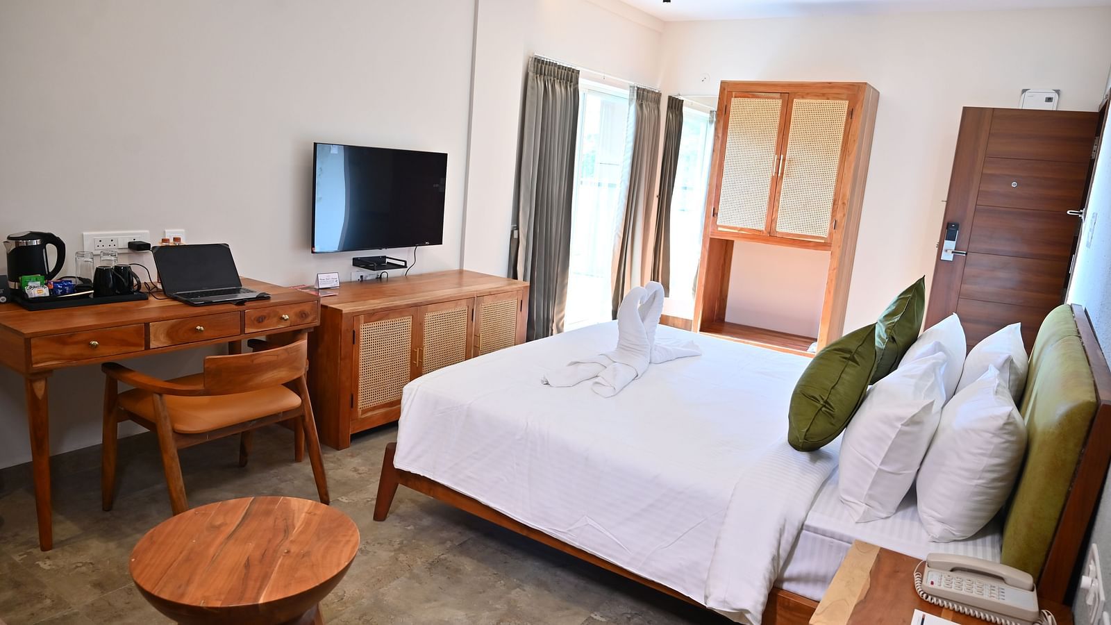Spacious Club Suite with a comfy bed, a wooden desk, a TV, a wardrobe, and large windows letting in natural light at TGI Livancia Hillside