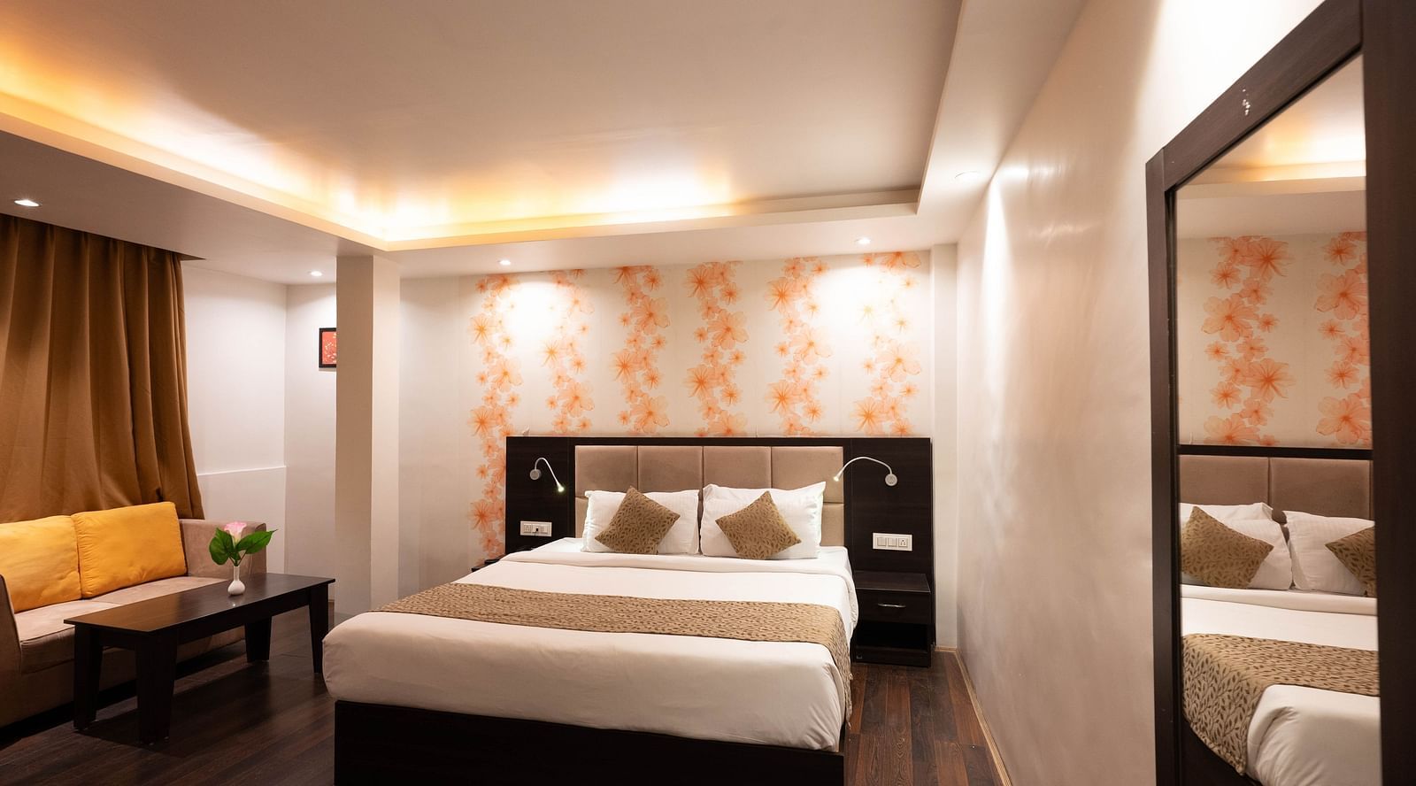 A bedroom with a seating arrangement beside it, and a curtain drawn over the window at Avianna Hungry Jack, Gangtok.