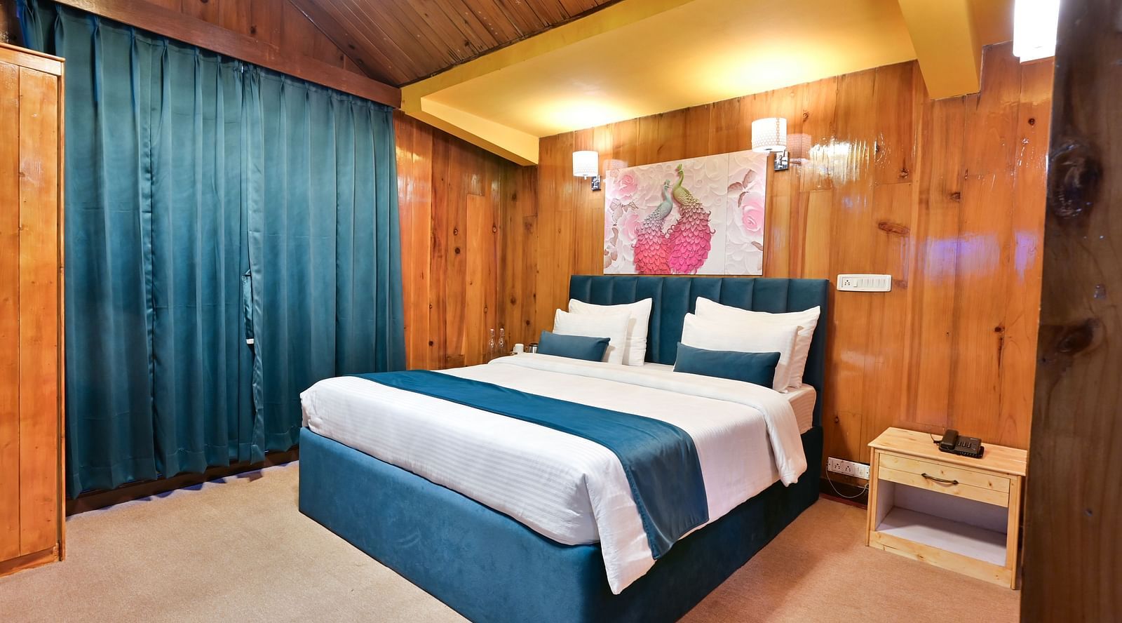 Premium room featuring a king sized bed, wall mounted television, windows with curtains, and warm lighting at Avianna Seven Seas, Darjeeling3