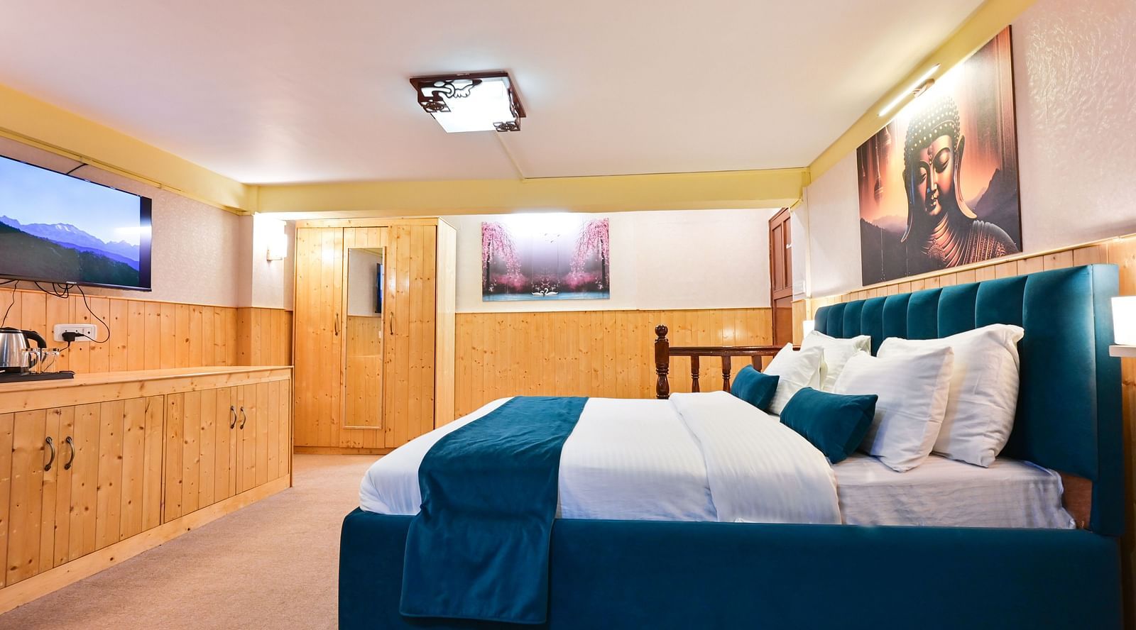 Premium room featuring a king sized bed, wall mounted television, windows with curtains, and warm lighting at Avianna Seven Seas, Darjeeling4