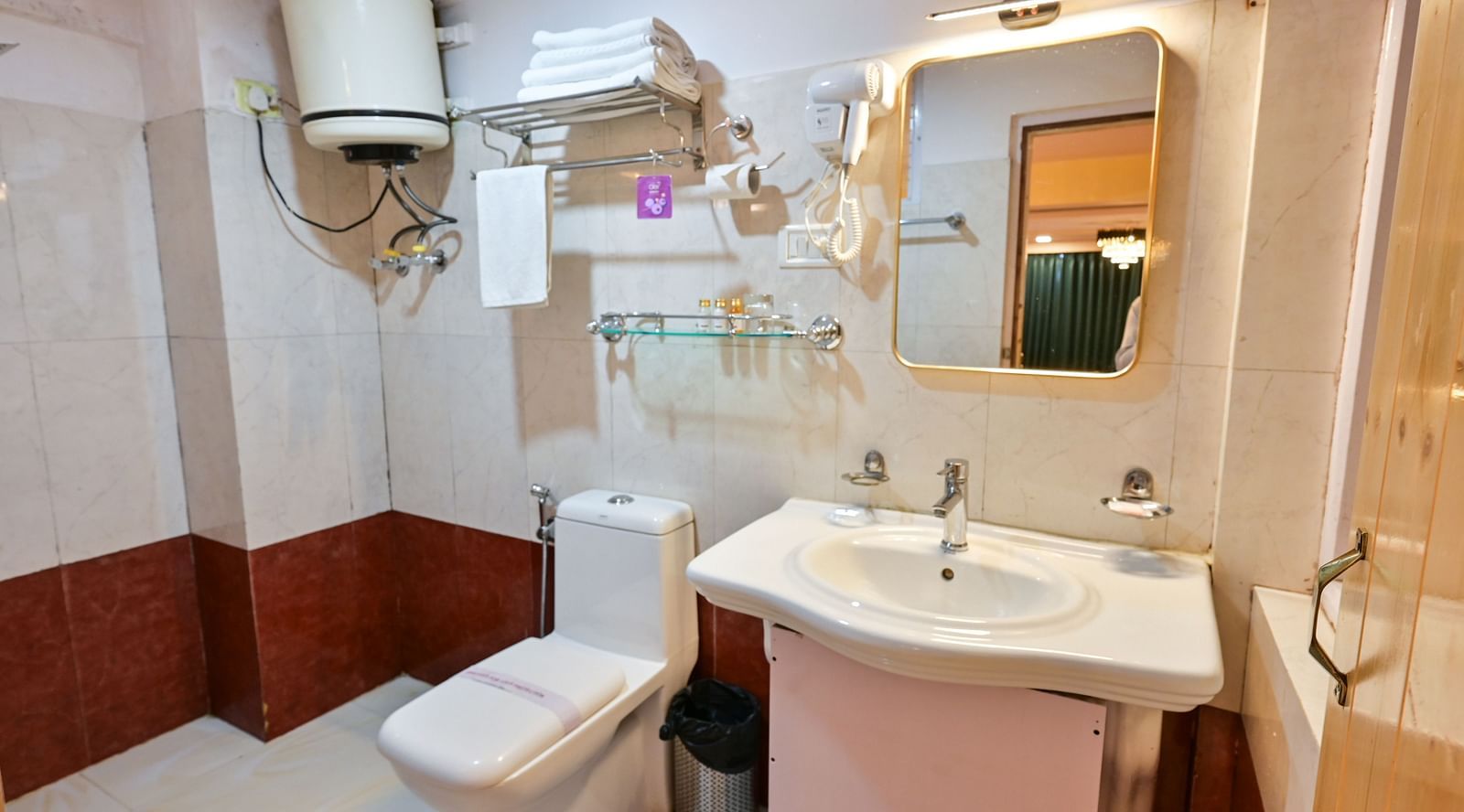 The suite features a spacious bathroom equipped with a washbasin, mirror, geyser, and western toilet at Avianna Seven Seas, Darjeeling2
