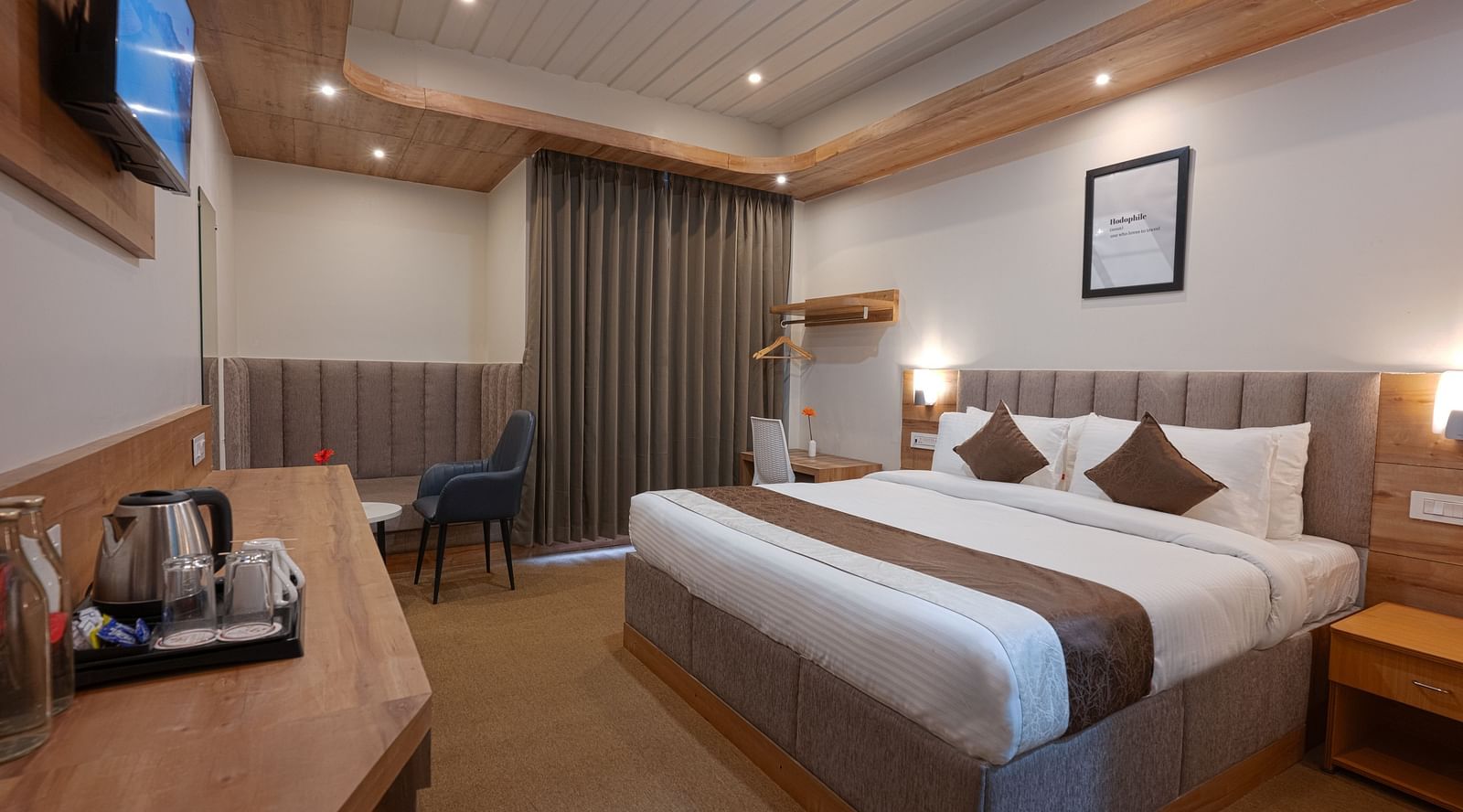 image of the deluxe room with a wall mounted television at the soma hotel by avianna group, darjeeling