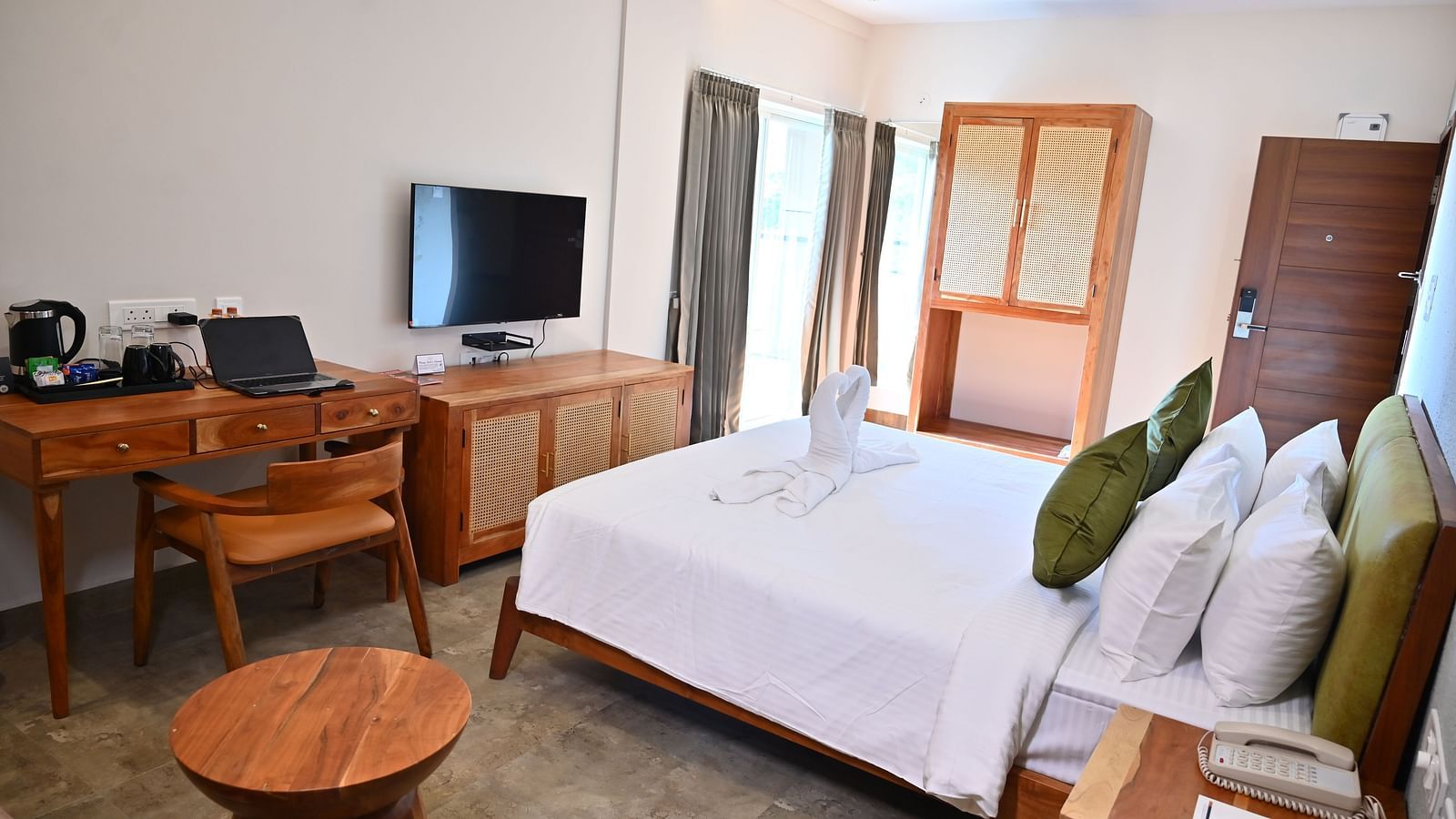 Spacious Club Suite with a comfy bed, a wooden desk, a TV, a wardrobe, and large windows letting in natural light at TGI Livancia Hillside