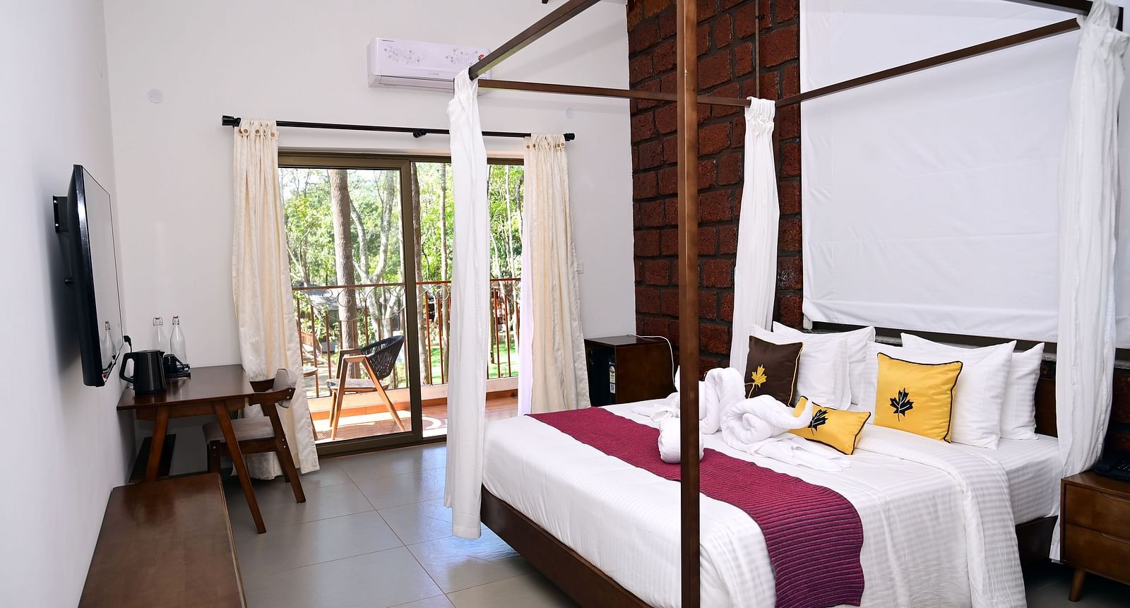 An image of a Premium Cottage featuring a poster bed, a flat TV screen, a work desk and chair, and a balcony - TGI Redolent Resort, Kushalnagar, Coorg