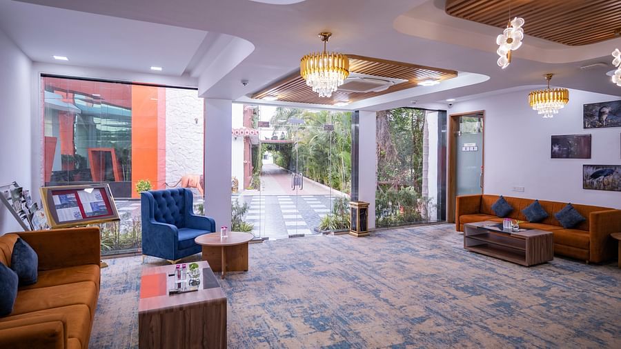 A wide view of Clarks Safari Kheda's lobby, showing seating areas, a central pathway leading to an open entrance, and wall decor.