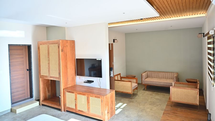 Suite with wooden furniture, including a wardrobe, a TV unit, and a cosy seating area near large window at TGI Livancia Hillside