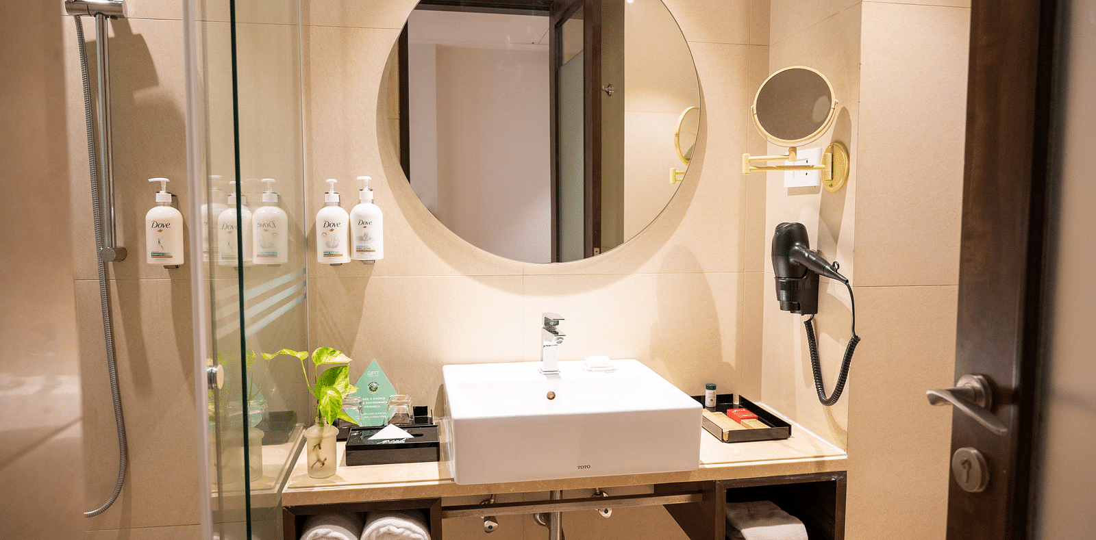 an image of bathroom with a mirror and toiletries at Grand Kakinada by GRT Hotels