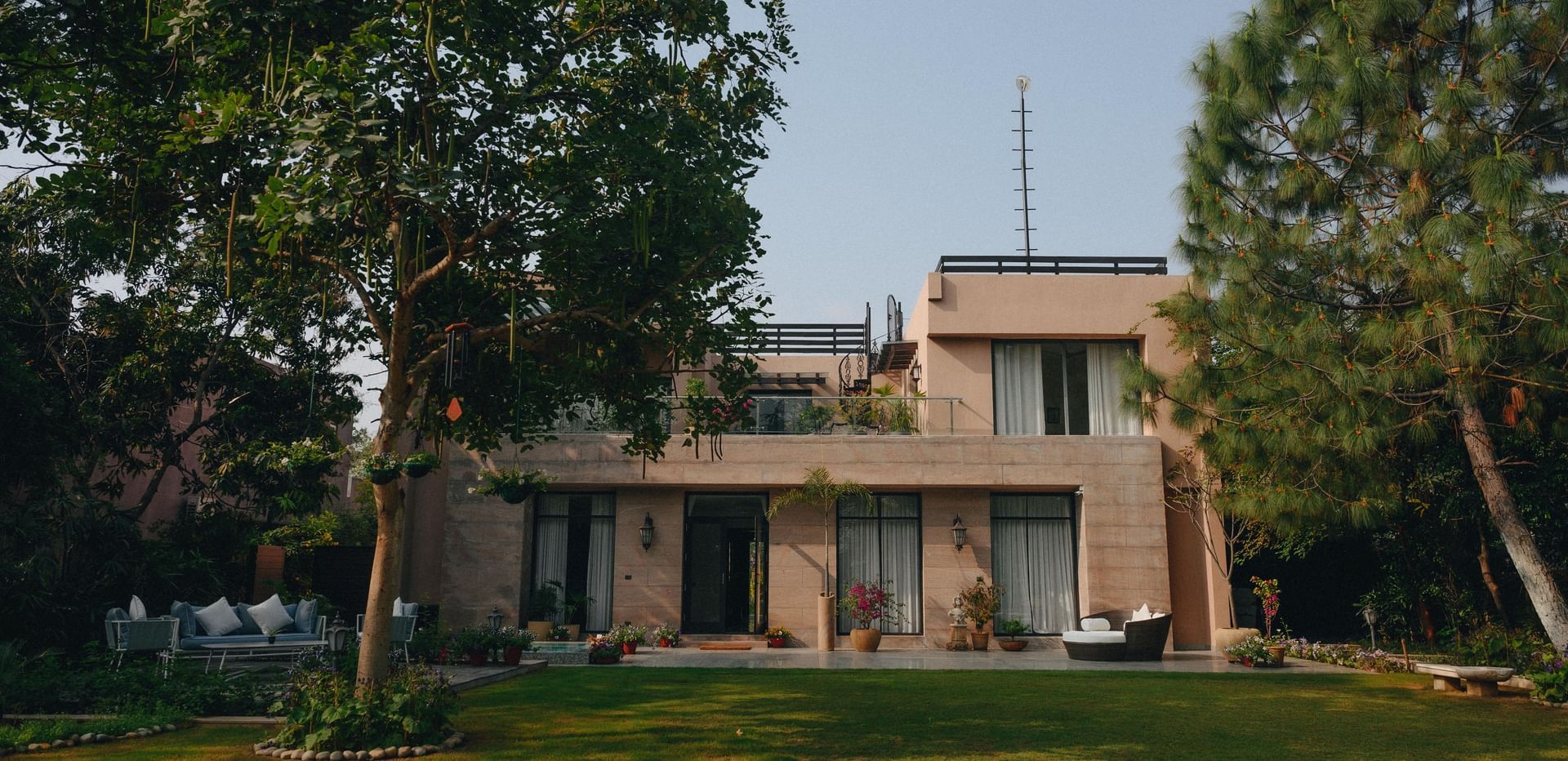 Luxury Villa in Delhi NCR at Karma Chalets, featuring a lawn surrounded by trees, and a lawn.