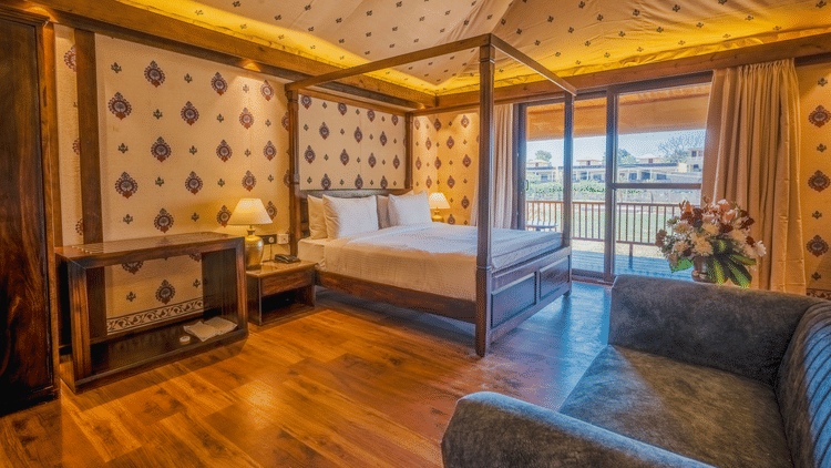 A Premium Duplex Tent featuring  a plunge swimming pool, a sofa set, with centre table, and a flight of wooden stairs at The Baagh Ananta Elite, Ranthambore