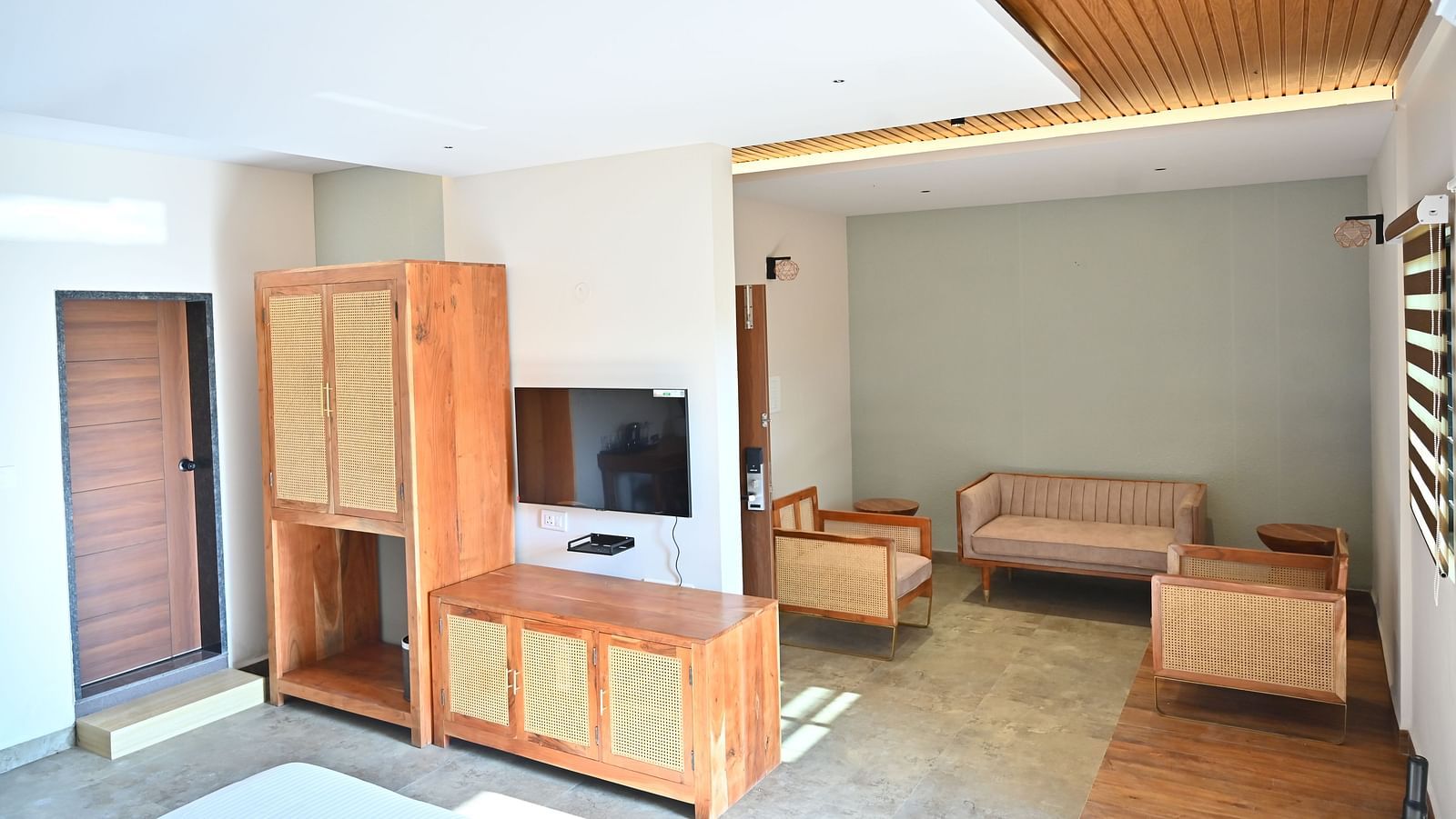 Suite with wooden furniture, including a wardrobe, a TV unit, and a cosy seating area near large window at TGI Livancia Hillside