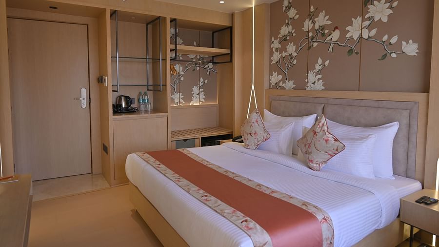 A side view of the bedroom with flower-painted walls, featuring a bed and elegant decor at Clarks Collection Grand Sapphire, Ajmer.