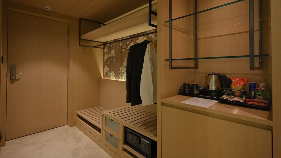 Open wardrobe with neatly arranged shirts hanging on wooden hangers at Clarks Collection Grand Sapphire, Ajmer.