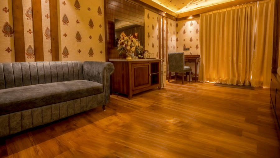 A Premium Duplex text room featuring a  sofa, a cabinet table with flower vase, mirror attached on the wall, and a work desk and chair at The Baagh Ananta Elite, Ranthambore