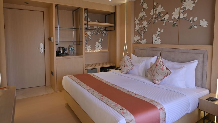 A side view of the bedroom with flower-painted walls, featuring a bed and elegant decor at Clarks Collection Grand Sapphire, Ajmer.