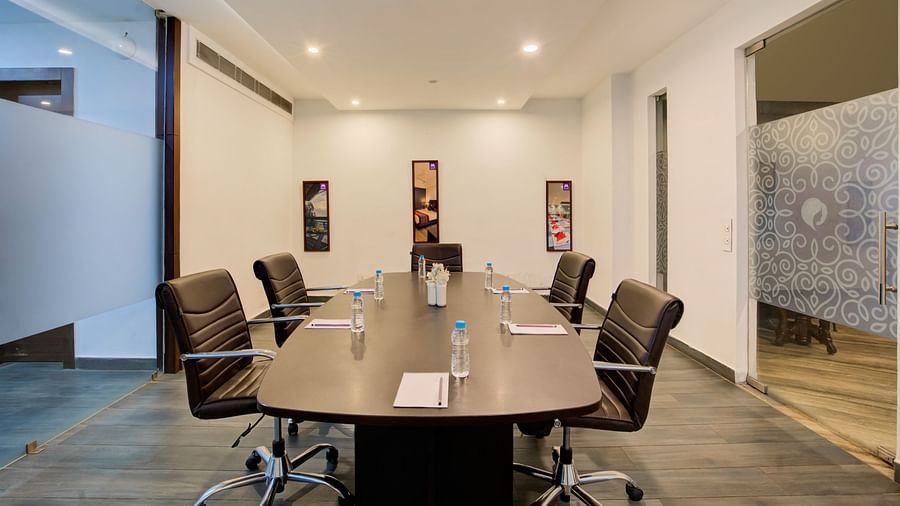 Private meeting space with a sleek conference table, stylish wall art, and ambient lighting at Voyage Milestone Hotel and Banquet Siliguri