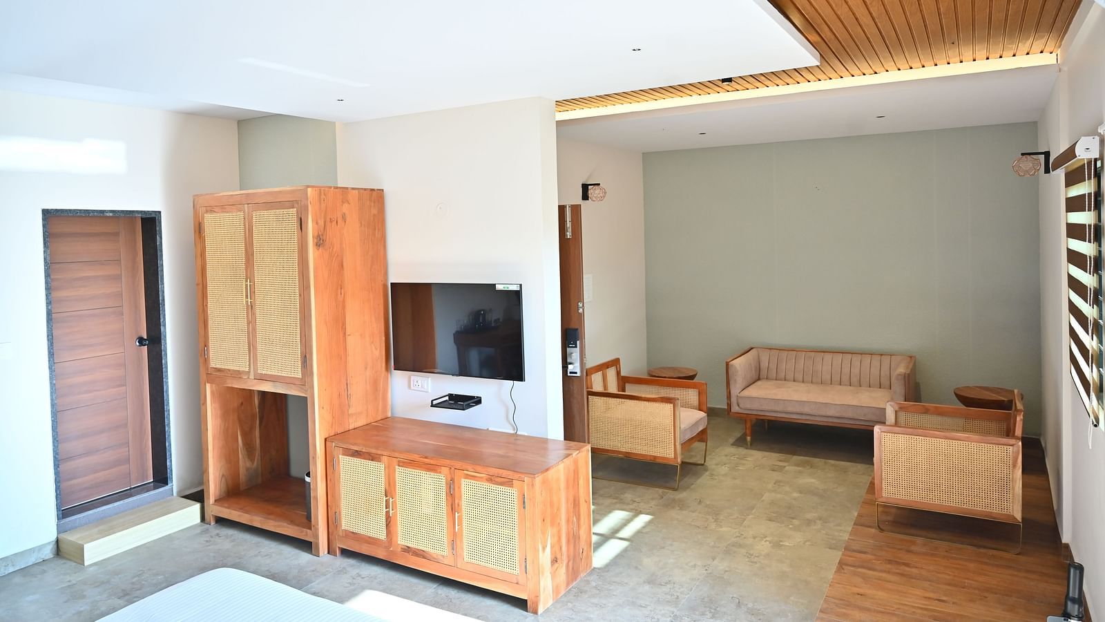 Suite with wooden furniture, including a wardrobe, a TV unit, and a cosy seating area near large window at TGI Livancia Hillside